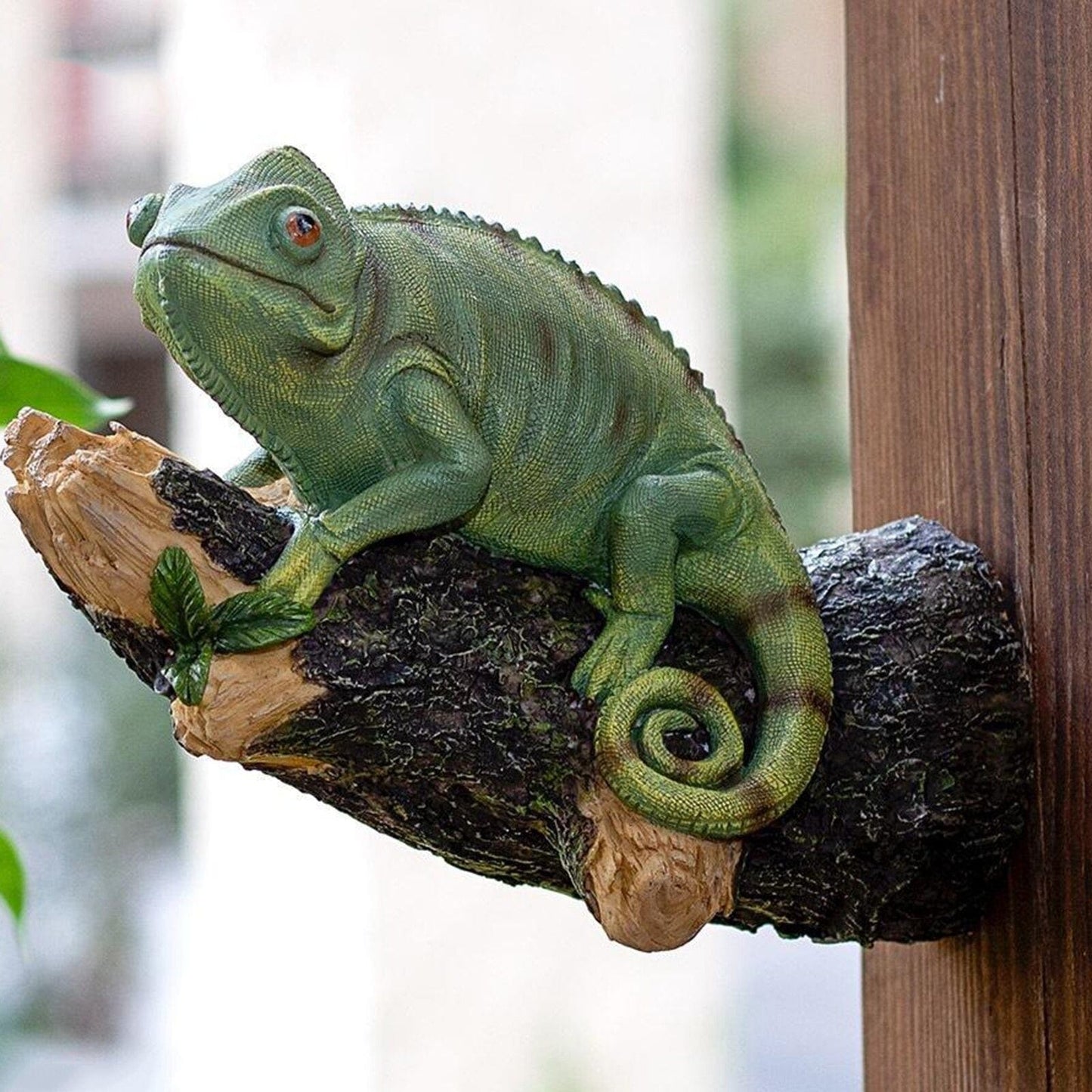 Estatueta de camaleão de resina na árvore